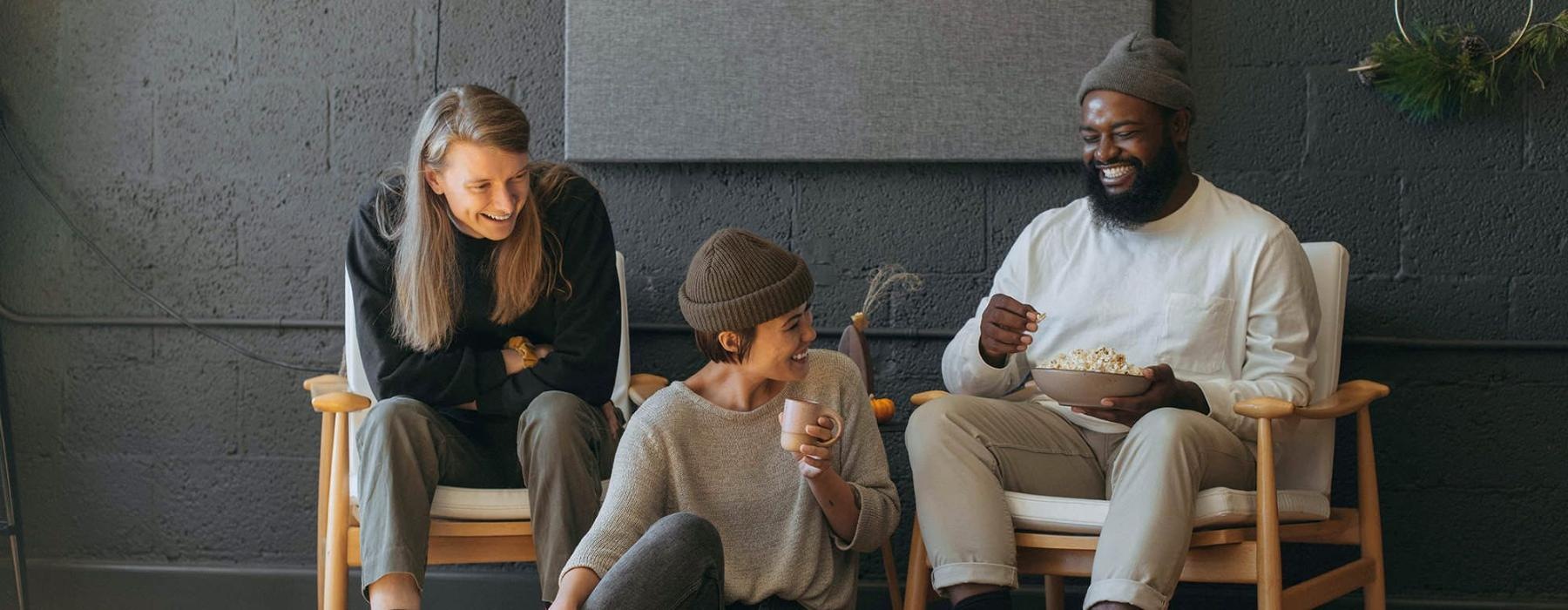 friends sit together around an open laptop